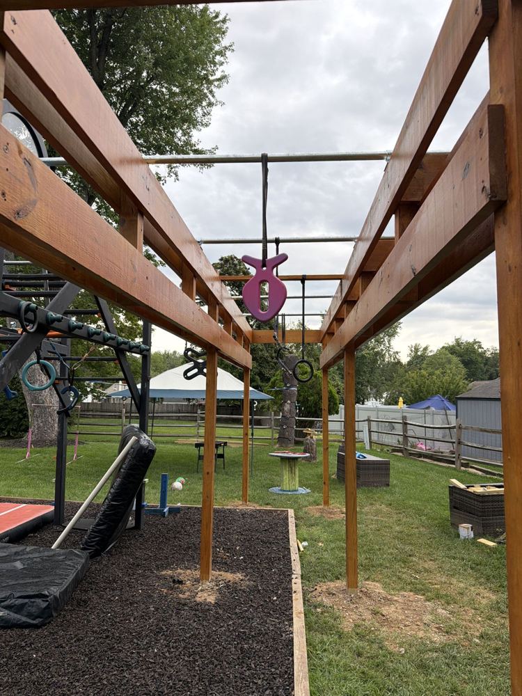 View down the length of a stained ninja rig with a pink grip hanging from the steel bars